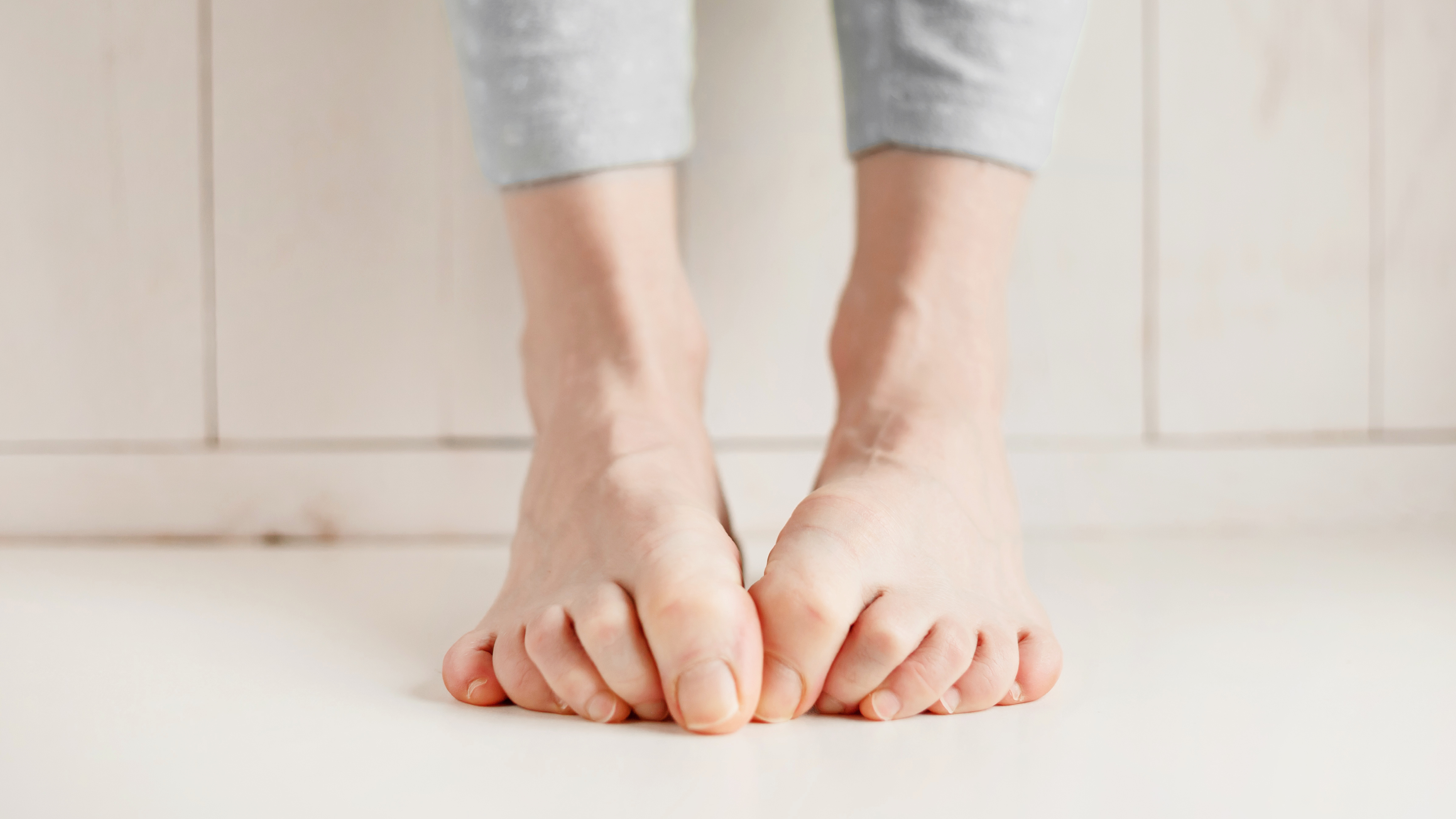 Frau versteckt Fußnägel aufgrund von eingewachsenen oder eingerollten Nägeln.